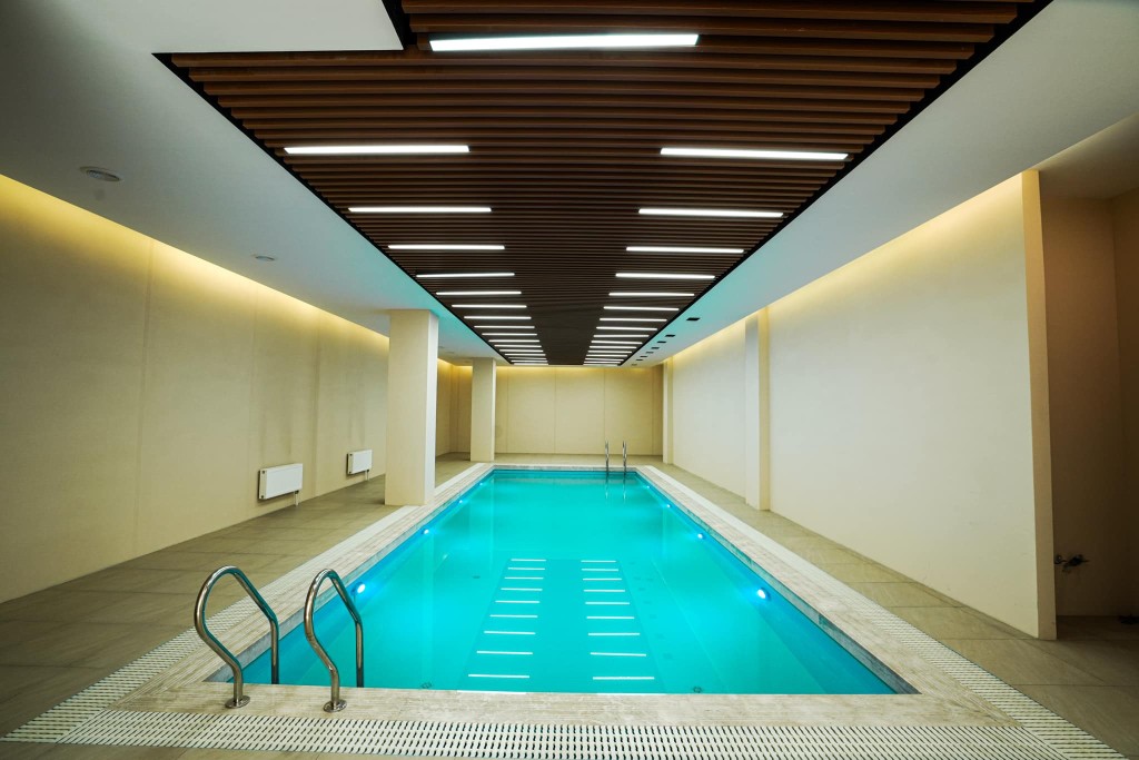 Indoor swimming pool with adjacent sauna in a modern wellness facility